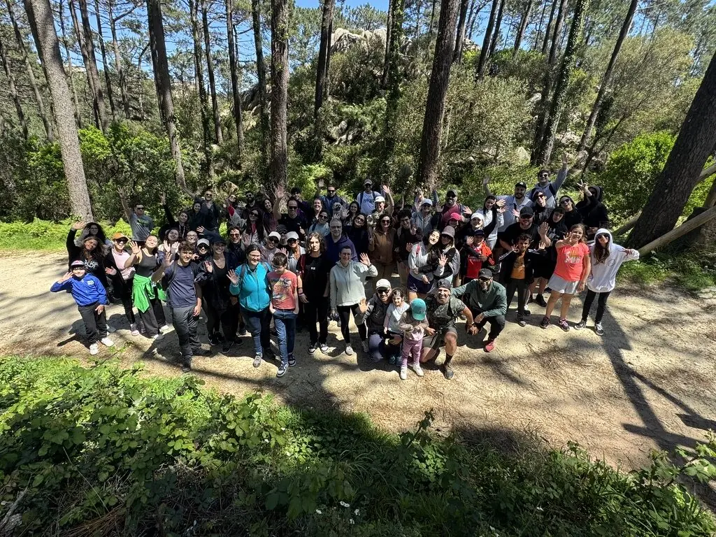 Homens e famílias caminhando numa área arborizada